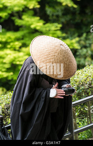 Moine japonais avec mendicité debout vers une porte d'un temple au Japon Banque D'Images