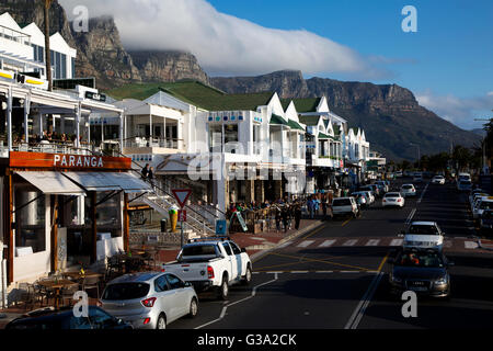 Scène de rue à Victoria Road, Camps Bay Beach, avec table montagnes en arrière-plan, Le Cap, Afrique du Sud Banque D'Images