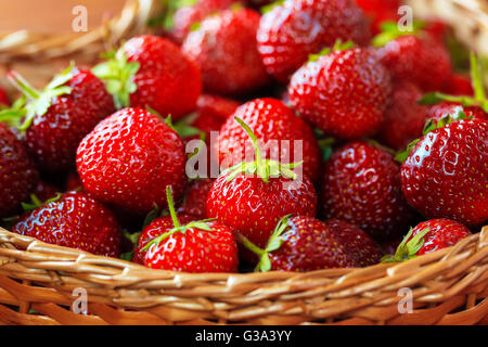 Très belle arrière-plan avec des fraises fraîches dans un panier en osier en forme de coeur en osier Banque D'Images