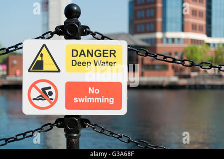 Un signe qui se lit l'eau profonde de danger Pas de piscine par le bassin du lac Érié à Salford Quays de Greater Manchester. Banque D'Images