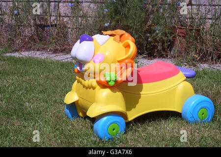 2015 mai - vue basse d'une promenade en plastique d'un enfant sur le jouet lion dans le jardin. Banque D'Images