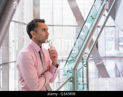 Pensive businessman in corporate office lobby moderne Banque D'Images