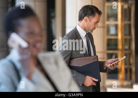 Corporate businessman using digital tablet outdoors Banque D'Images