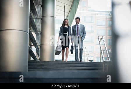 Corporate businessman and businesswoman descendant quelques marches à l'extérieur Banque D'Images