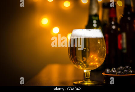 Pinte de bière artisanale sur bar, avec des bouteilles de bière Banque D'Images