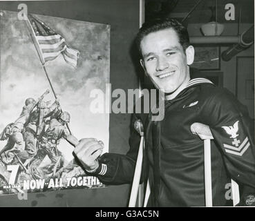 Pharmacien de la marine 4400 deuxième classe John H. Bradley points à la 7e guerre mondiale affiche Prêt qui porte l'image de l'historique du drapeau sur le mont Suribachi, Iwo Jima. Bradley a participé à l'événement tout en restant fixé à une unité de Marines dans la bataille. Banque D'Images