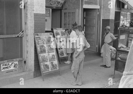 Enfants regardant des affiches devant le film, samedi, Ste Banque D'Images