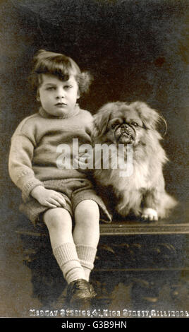 ENFANT AVEC UN ENFANT PÉKINOIS Banque D'Images