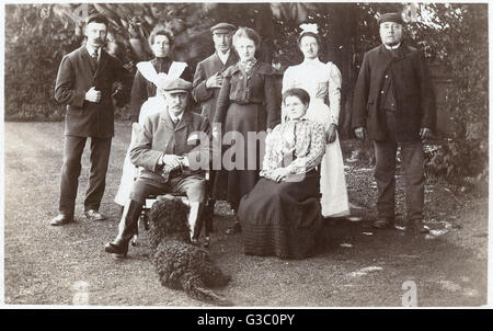 Groupe familial avec caniche noire dans un jardin Banque D'Images