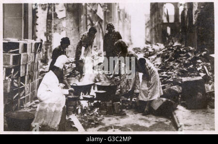 WW2 - son restaurant et cuisine détruit par les bombardements allemands, un chef continue de cuisiner en plein air dans une rue bombardée - Blitz, Londres. Date : vers 1941 Banque D'Images