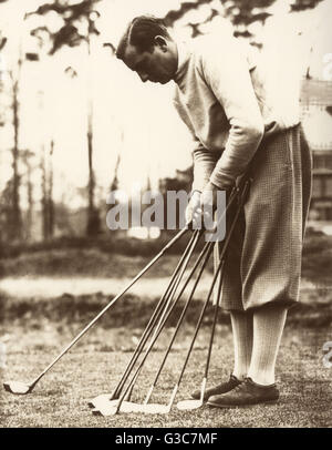 Sir Thomas Henry Cotton (1907-1987), golfeur professionnel anglais qui a remporté trois championnats ouverts, qu'on voit ici sur un terrain de golf et des clubs de vérifier ses putters. Date : vers 1930 Banque D'Images