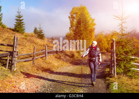 Female Hiker marche sur Sentier en forêt d'automne Banque D'Images