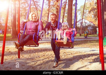 Les jeunes Jolly Family having fun on Kids Seesaw dans Park Banque D'Images