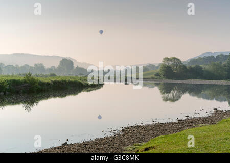 La première lumière à Reeth dans Swaledale, le Yorkshire Dales, et un ballon à air chaud au-dessus de la rivière Swale. Banque D'Images