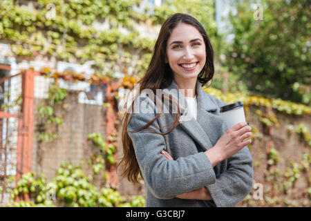 Smiling beauiful cheerful girl holding café tasse à emporter à l'extérieur Banque D'Images