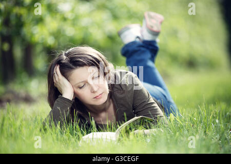 Femme lisant un livre dans le verger Banque D'Images