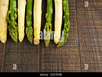 Asperges blanches et vertes sur fond de bois avec de l'espace vide pour le texte en bas et vers la droite. Dessus plat horizontal,vie Banque D'Images