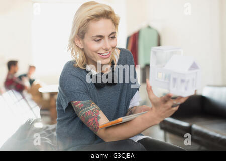 Souriante jeune femme tatouée architect holding model Banque D'Images