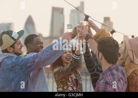 Young adult friends toasting champagne glasses at rooftop party Banque D'Images