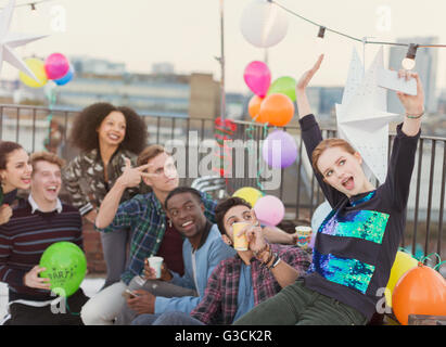 Jeunes adultes enthousiastes friends at rooftop party selfies Banque D'Images