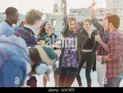 Jeunes adultes ludique friends dancing at rooftop party Banque D'Images