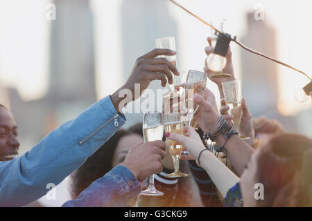 Young adult friends toasting champagne flutes at party Banque D'Images