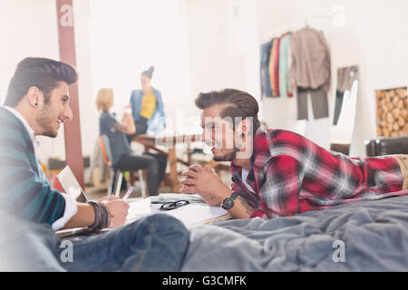 College students studying sur lit dans l'appartement Banque D'Images