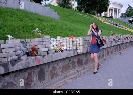 Une femme ukrainienne passe par rangée de fleurs par rangée de fleurs placées dans l'allée des héros tombés Nommé en mémoire de 100 manifestants tués par des tireurs d'élite inconnus lors de la révolution ukrainienne de février 2014 également connue Comme la Révolution Euromaidan ou la Révolution de la dignité dans Maidan Nezalezhnosti ou la place de l'indépendance dans le centre de la capitale de Kiev De l'Ukraine Banque D'Images