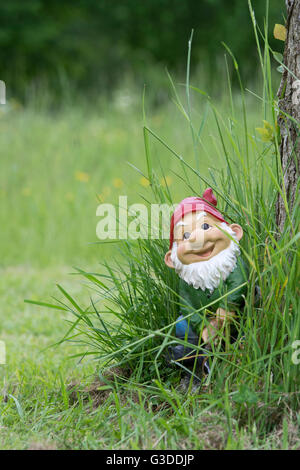 Happy smiling garden gnome dans l'herbe haute Banque D'Images