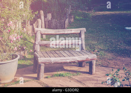 Chaise de bois dans le jardin et du soleil avec vintage tone. Banque D'Images