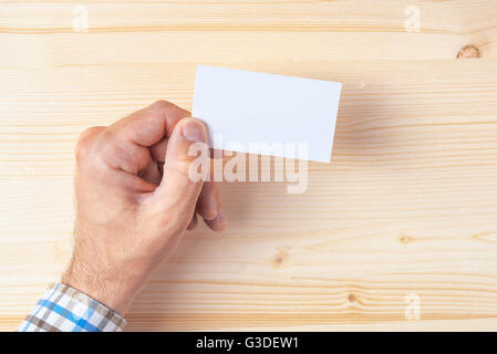 Top View of businessman holding blank business card sur Office 24, copie la maquette de l'espace pour la conception graphique ou de positionnement du texte. Banque D'Images