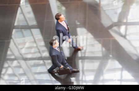 Les hommes d'entreprise marche dans le hall bureau moderne Banque D'Images