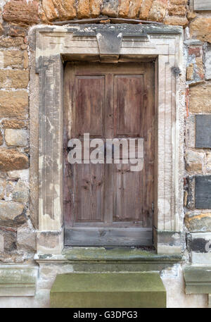 Vieille porte en bois, dans un portail en pierre Banque D'Images