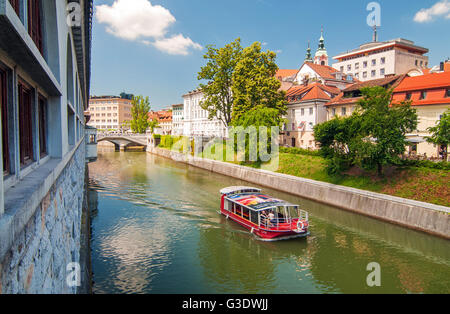 Ljubljana, Slovénie - 7 juin 2016 Bateau sur la rivière Ljubljanica et Triple ponts en fond sur une journée ensoleillée Banque D'Images