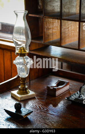 Une vieille version comprenant bien l'encre et le long de buvard avec lampe au kérosène s'asseoir sur le vieux bureau en bois avec trou de pigeon cabinet Banque D'Images