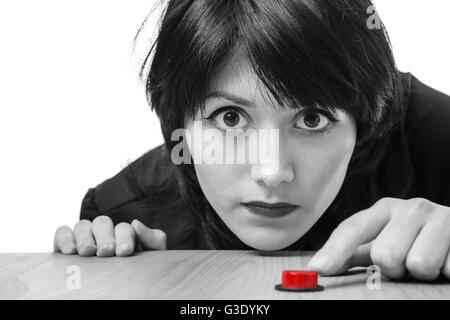 Close up studio shot d'un jeune modèle d'affaires portant un chemisier noir, prêt à appuyer sur un bouton rouge. Isolé sur blanc. Banque D'Images