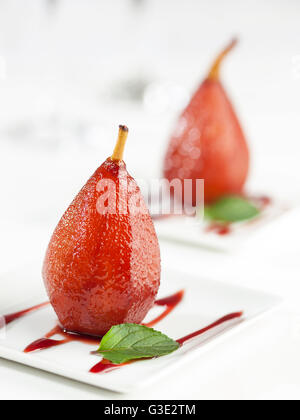 Un dessert sucré des poires cuites au vin rouge Banque D'Images