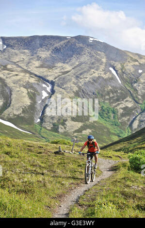 Femme conduit une pleine suspension vtt sur le sentier du col de la résurrection dans la Chugach National Forest, péninsule de Kenai, le centre-sud de l'Alaska Banque D'Images