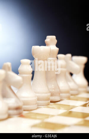 Ensemble de pièces d'échecs en onyx à bord sur un fond sombre Banque D'Images