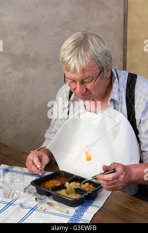 Un homme âgé en foyer de l'amour et son dîner prêt à l'emploi Banque D'Images