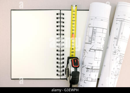 Rouleaux de plans architecturaux avec notepad et ruban de mesure sur 24 Banque D'Images