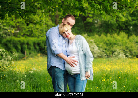 Couple heureux dans le parc, femme enceinte et son mari Banque D'Images