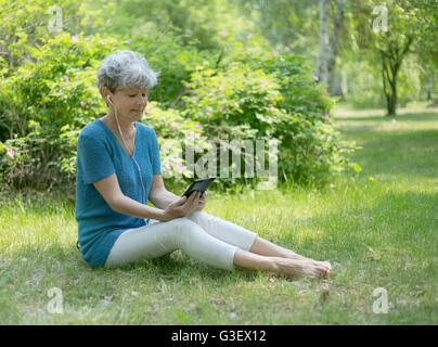 Smiling senior woman en utilisant son ordinateur tablette. Banque D'Images