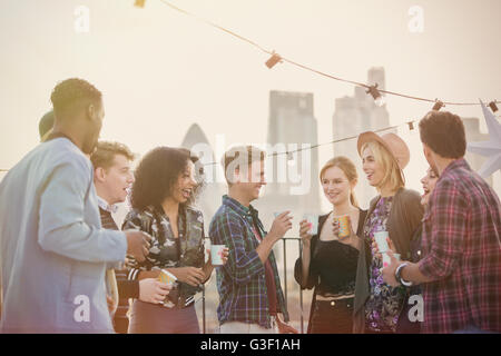 Les amis des jeunes adultes de boire et profiter de rooftop party Banque D'Images