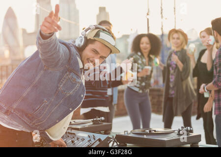 DJ enthousiaste Portrait gesturing at rooftop party Banque D'Images