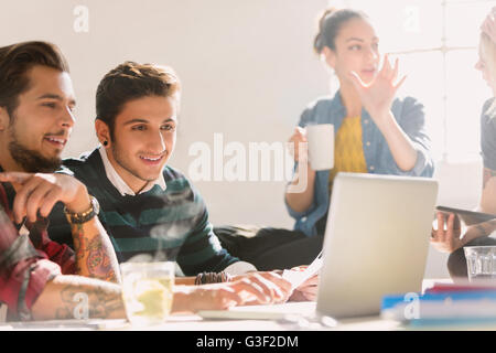 Creative young business people working at laptop Banque D'Images