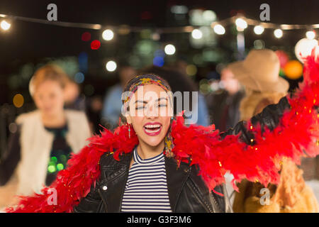 Portrait jeune femme enthousiaste dancing at rooftop party Banque D'Images