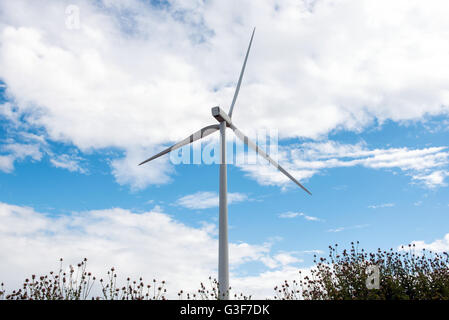 Seule éolienne contre un ciel nuageux ciel bleu dans un concept d'énergie renouvelable et des ressources naturelles Banque D'Images