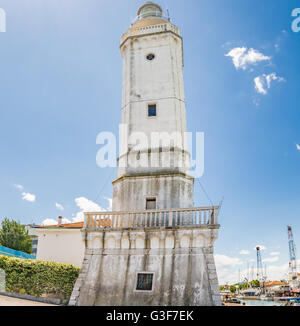 Vue sur le phare du 18ème siècle qui veille sur le port du canal, avec des bâtiments anciens et modernes dans la région de Rimini, Italie Banque D'Images