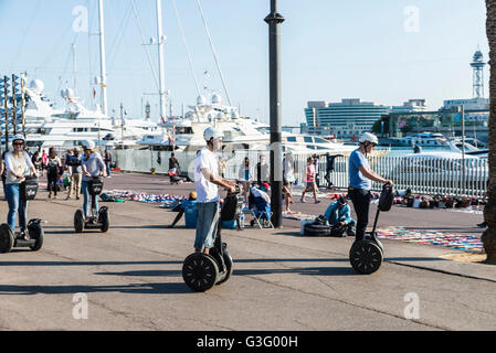 Les touristes sur un segway dans la promenade du front de mer plein de touristes et avec un marché aux puces à Barcelone, Catalogne, Espagne Banque D'Images